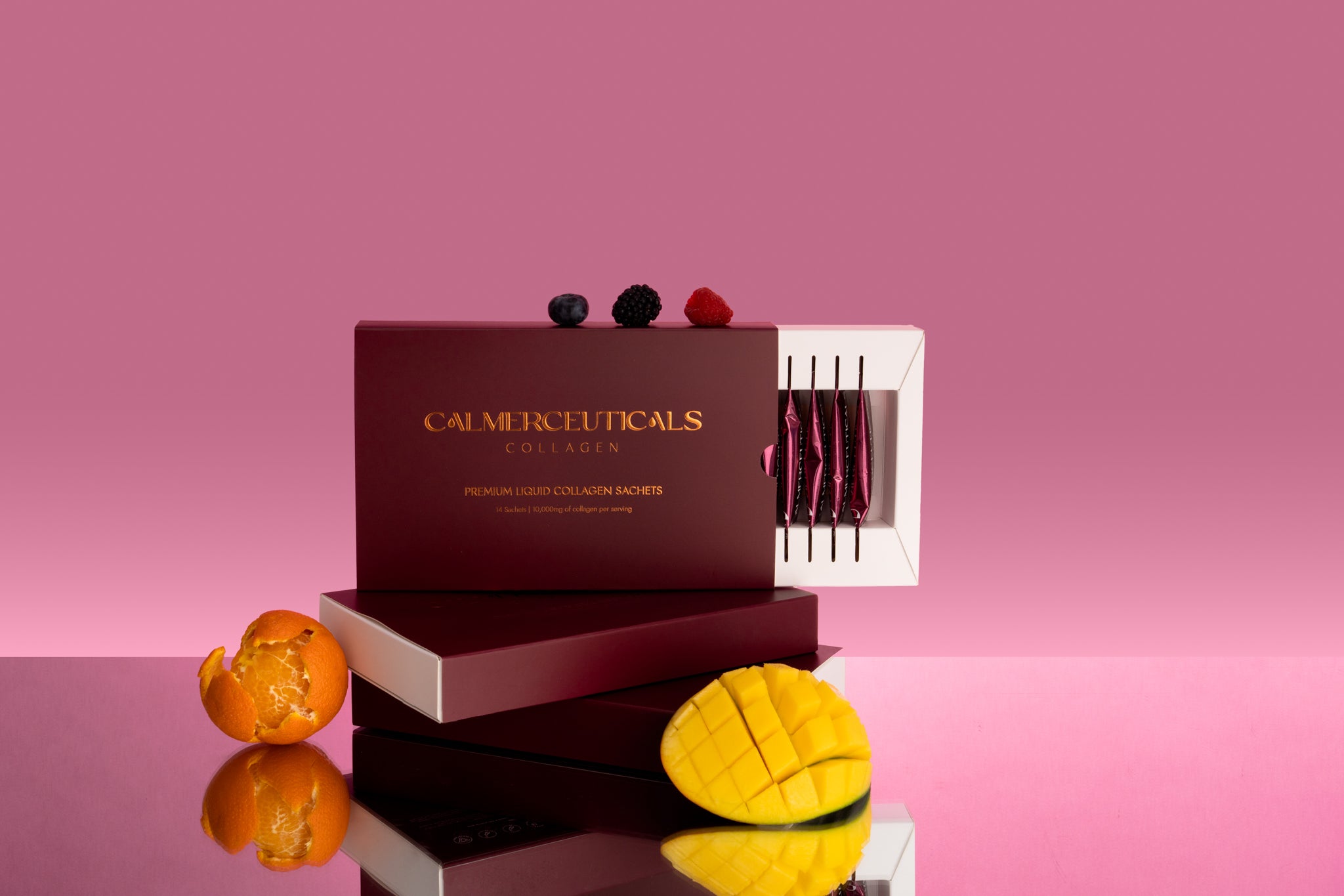 Calmerceuticals premium collagen liquid shots with mango and mandarin on a pink background.